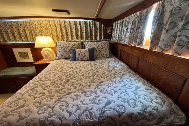 Slide: The Image of Cozy bedroom interior of 1979 Hatteras 53 Motor Yacht with patterned bedding and curtains. - 38
