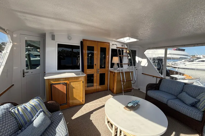 Slide: The Image of Interior of 1979 Hatteras 53 Motor Yacht with cozy seating and marina view. - 4