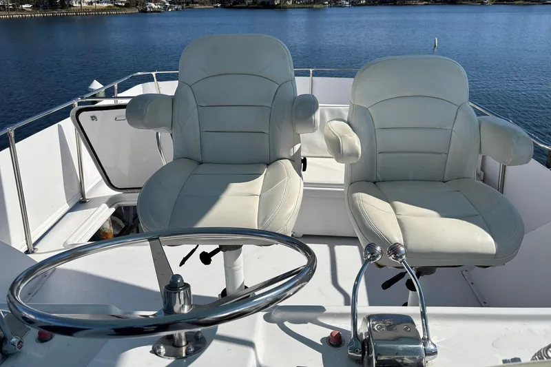 Slide: The Image of Captain's chairs on 1979 Hatteras 53 Motor Yacht, overlooking serene water. - 47