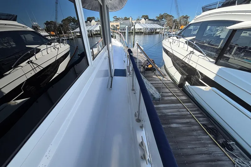 Slide: The Image of 1979 Hatteras 53 Motor Yacht docked at marina, side view with clear blue sky. - 48