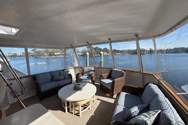 Slide: The Image of 1979 Hatteras 53 Motor Yacht interior with cozy seating and scenic water views. - 5