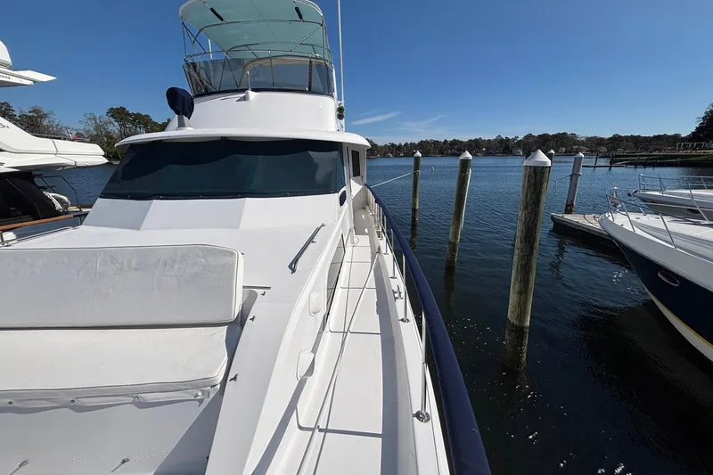 Slide: The Image of 1979 Hatteras 53 Motor Yacht docked at marina under clear blue sky. - 51