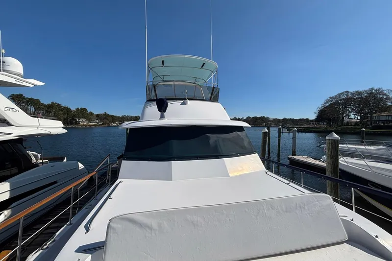 Slide: The Image of 1979 Hatteras 53 Motor Yacht docked at marina under clear blue sky. - 53