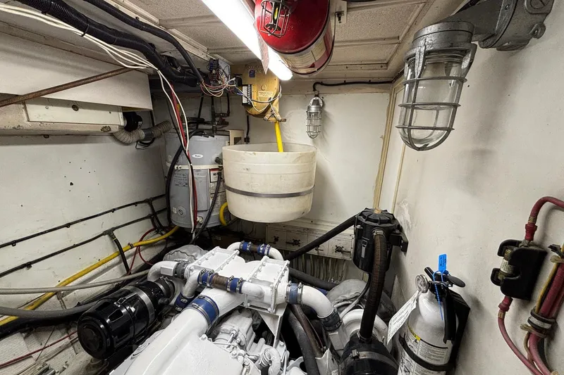 Slide: The Image of Engine room of a 1979 Hatteras 53 Motor Yacht with visible machinery and wiring. - 59