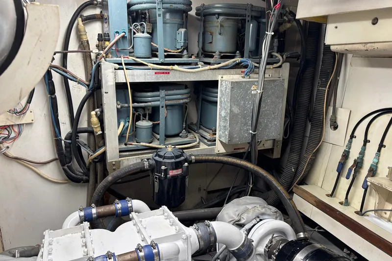 Slide: The Image of Engine room of a 1979 Hatteras 53 Motor Yacht, showcasing mechanical components and wiring. - 61