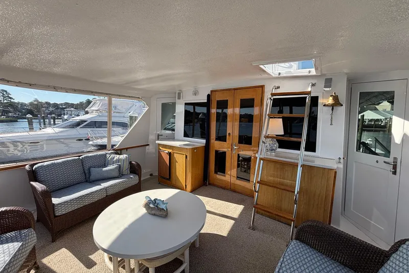 Slide: The Image of 1979 Hatteras 53 Motor Yacht interior with cozy seating and nautical decor. - 7
