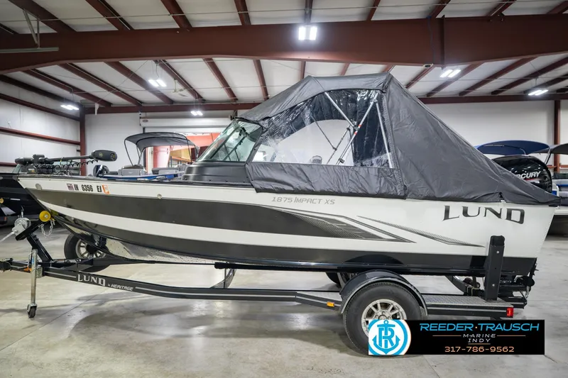 Slide: The Image of 2022 Lund 1875 Impact boat in showroom, covered, on trailer, Reeder Trausch Marine. - 11