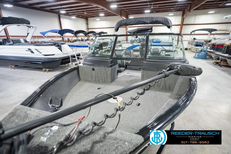 Slide: The Image of 2022 Lund 1875 Impact boat in showroom, featuring spacious interior and modern design. - 12