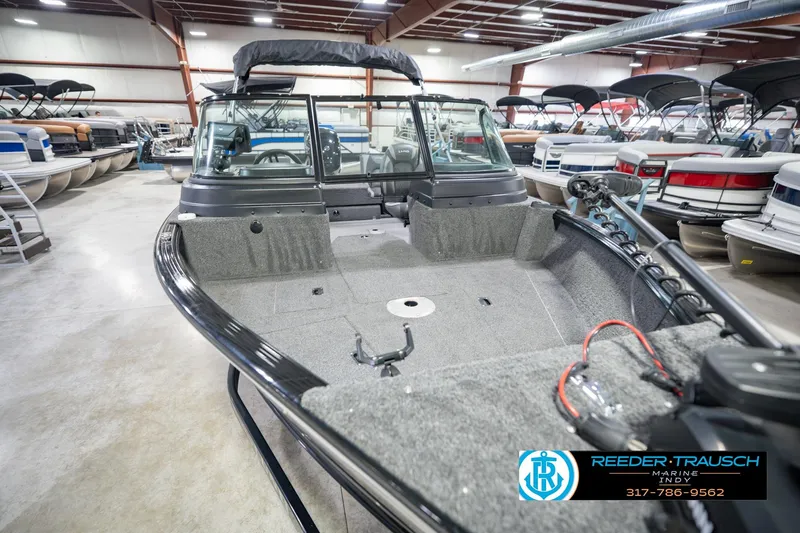 Slide: The Image of 2022 Lund 1875 Impact boat displayed in a showroom with other boats. - 13