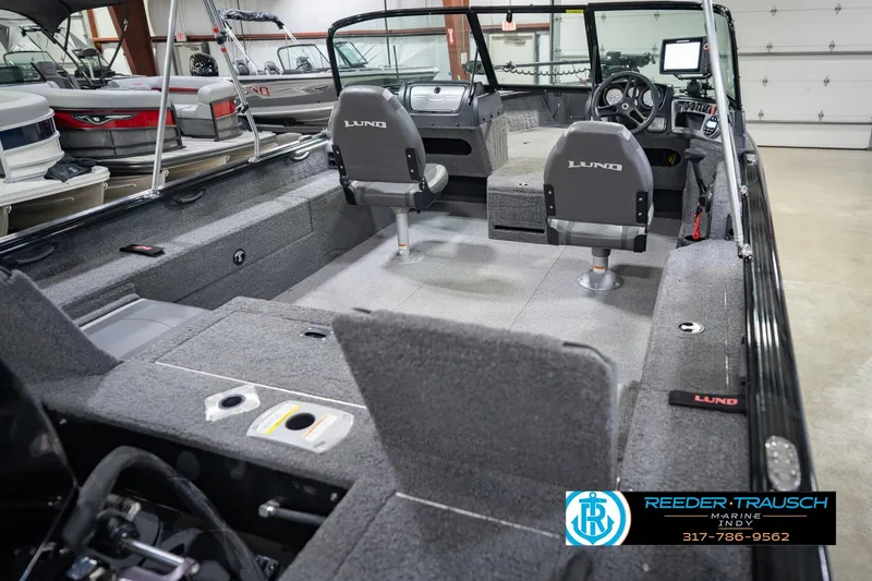 Slide: The Image of 2022 Lund 1875 Impact boat interior with seating and steering console in showroom. - 14