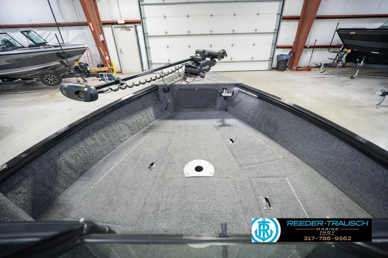 Slide: The Image of 2022 Lund 1875 Impact boat interior with trolling motor in a showroom. - 18