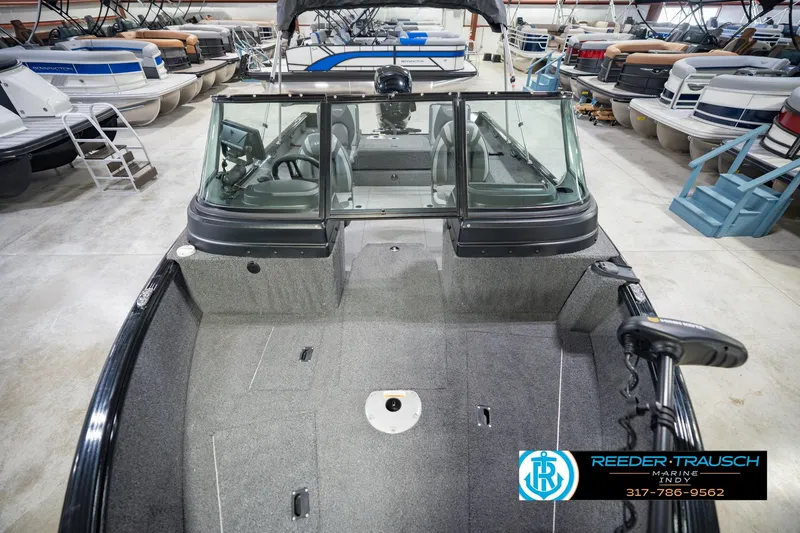 Slide: The Image of 2022 Lund 1875 Impact boat in showroom, surrounded by various pontoon boats. - 19