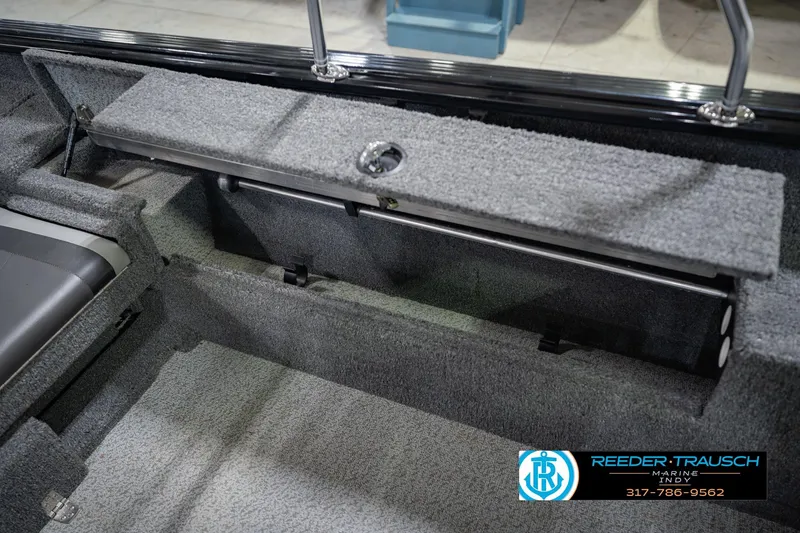 Slide: The Image of 2022 Lund 1875 Impact boat interior with storage compartment and carpeted flooring. - 26