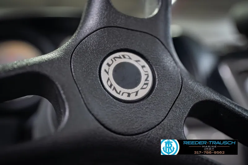 Slide: The Image of Steering wheel of 2022 Lund 1875 Impact boat, featuring brand logo. - 33