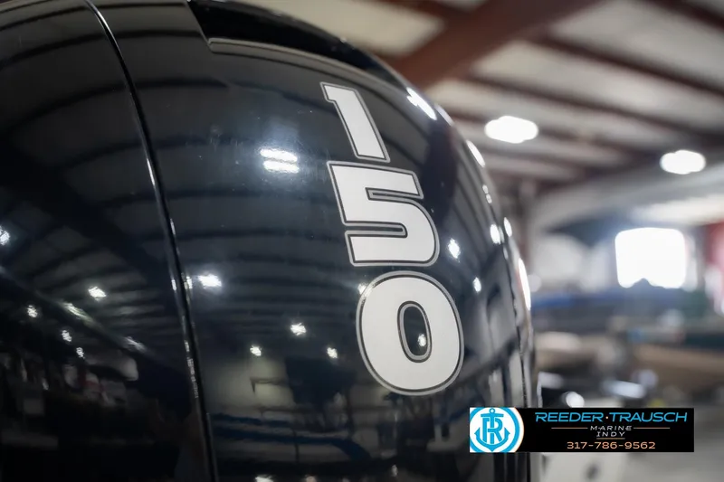 Slide: The Image of 2022 Lund 1875 Impact boat engine with "150" horsepower label in a showroom. - 49