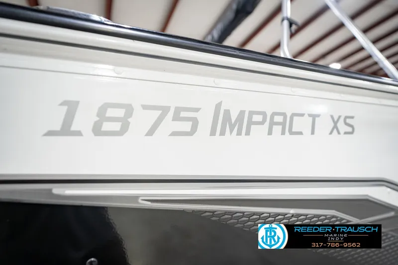 Slide: The Image of 2022 Lund 1875 Impact XS boat side view with branding and dealership logo. - 57