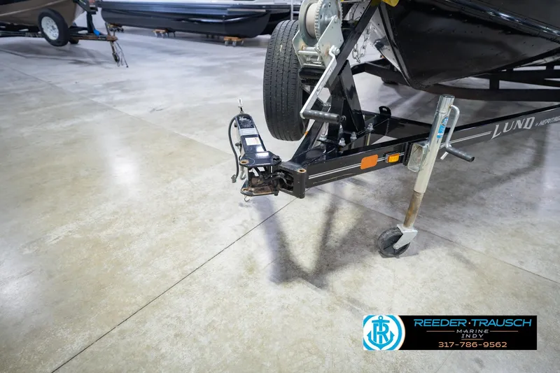 Slide: The Image of 2022 Lund 1875 Impact boat trailer in showroom with Reeder-Trausch Marine logo. - 59