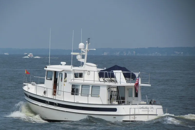 Slide: The Image of 2008 Nordic Tug 42 cruising on open water with American flag displayed. - 1