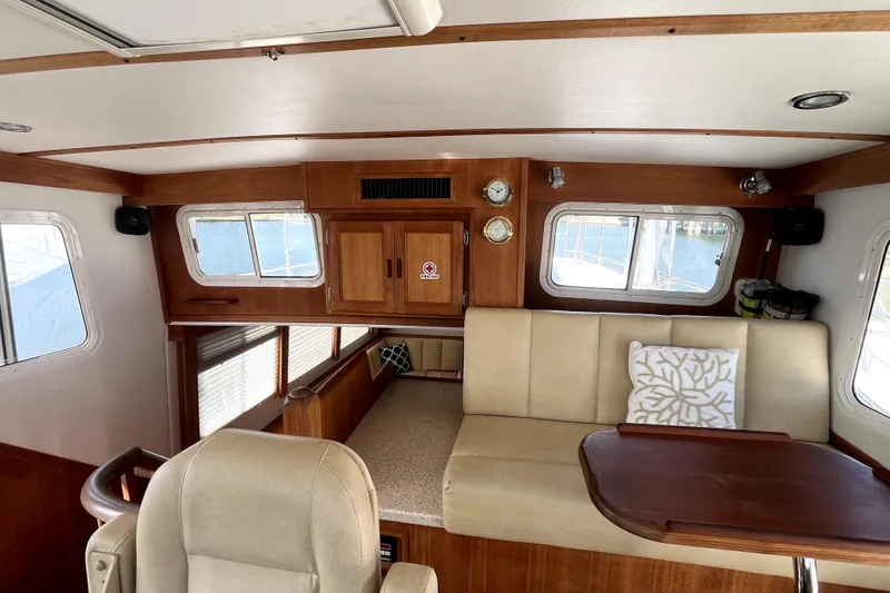 Slide: The Image of Interior of 2008 Nordic Tug 42 with beige seating, wooden accents, and nautical decor. - 12