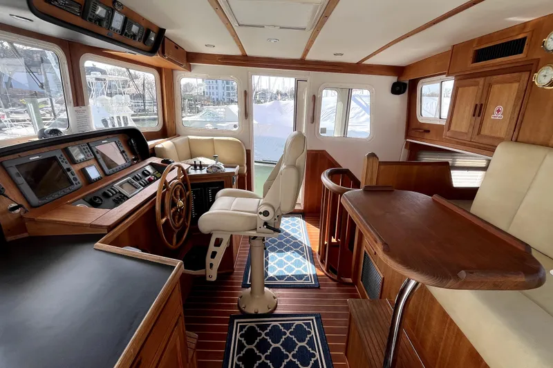 Slide: The Image of Interior of a 2008 Nordic Tug 42, featuring a helm station and wooden furnishings. - 14