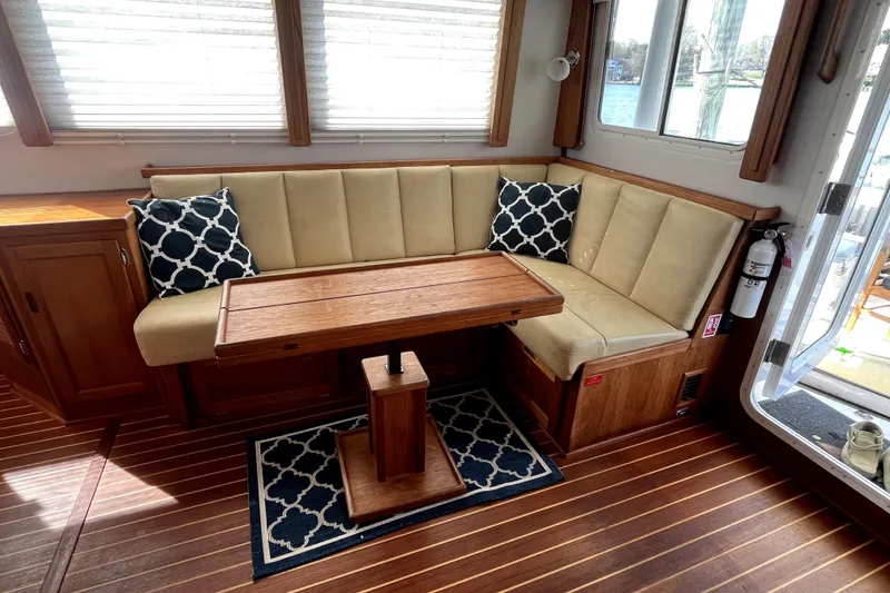 Slide: The Image of Cozy interior of 2008 Nordic Tug 42 with cushioned seating and wooden table. - 19