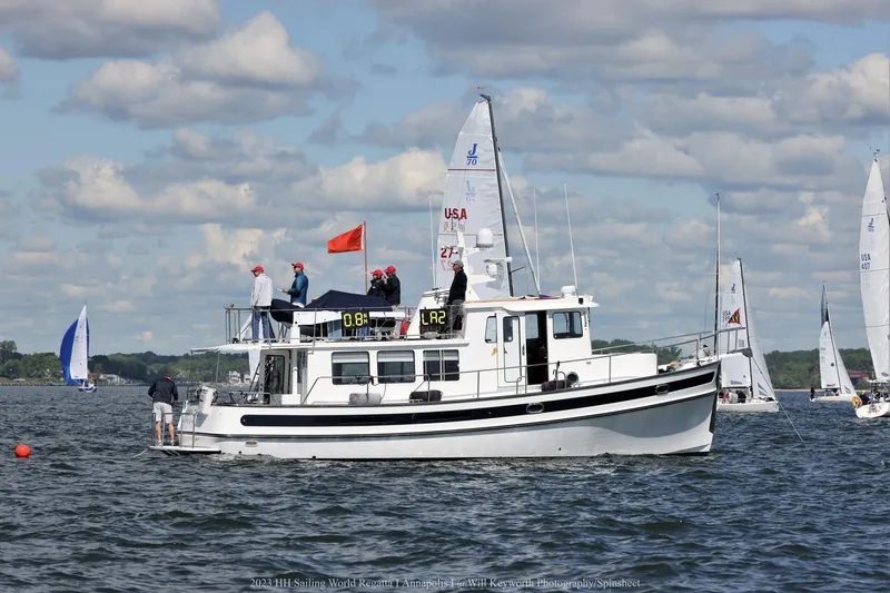 Slide: The Image of 2008 Nordic Tug 42 on water during sailing regatta, surrounded by sailboats under cloudy sky. - 2