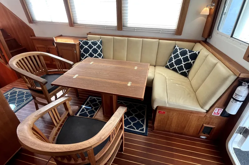 Slide: The Image of Cozy interior of 2008 Nordic Tug 42 with wooden table and cushioned seating. - 21