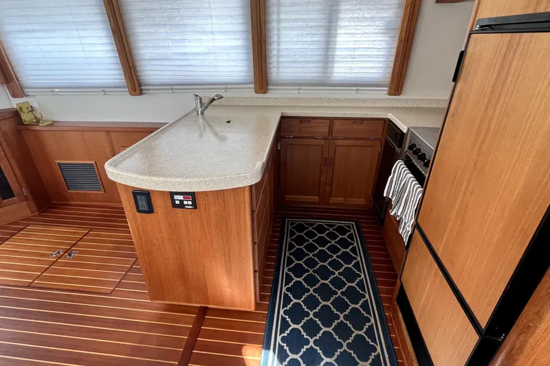 Slide: The Image of Interior of 2008 Nordic Tug 42, featuring a wooden kitchen with modern appliances. - 25