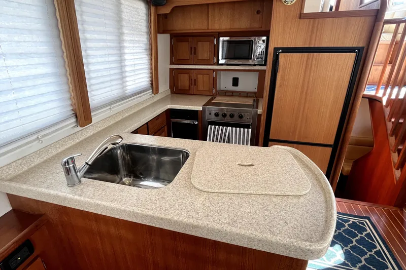 Slide: The Image of 2008 Nordic Tug 42 interior kitchen with sink, stove, and wooden cabinetry. - 27