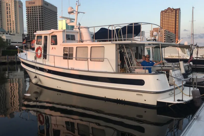 Slide: The Image of 2008 Nordic Tug 42 docked at marina with cityscape background. - 3