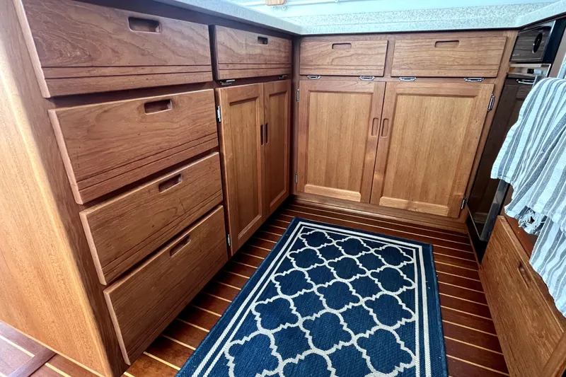 Slide: The Image of Wooden cabinetry in 2008 Nordic Tug 42 galley with patterned rug and striped towel. - 31