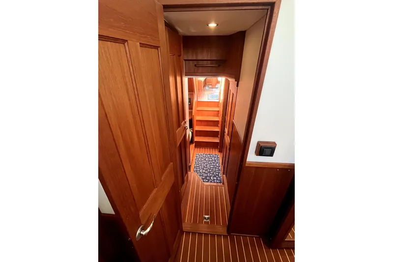 Slide: The Image of Interior view of 2008 Nordic Tug 42, featuring wooden paneling and carpeted stairs. - 32