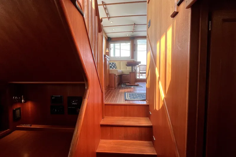 Slide: The Image of Interior of 2008 Nordic Tug 42, featuring wooden stairs and cozy seating area. - 33