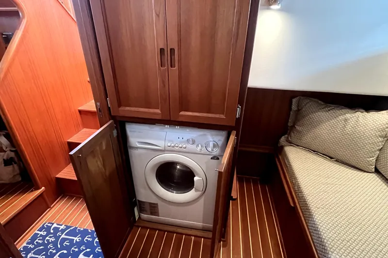 Slide: The Image of Laundry area with washer in 2008 Nordic Tug 42 boat cabin, featuring wooden cabinetry. - 43