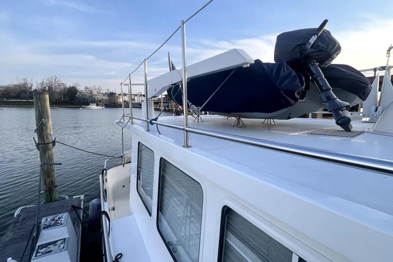 Slide: The Image of 2008 Nordic Tug 42 docked, featuring upper deck and water view. - 54