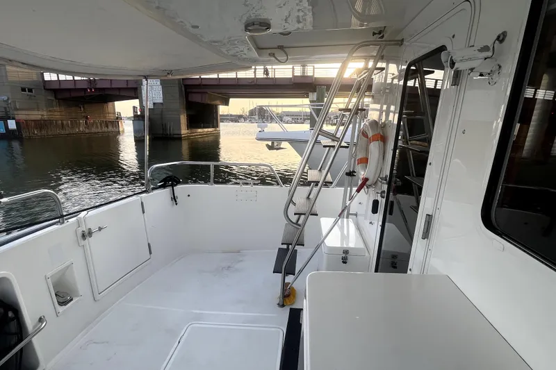 Slide: The Image of 2008 Nordic Tug 42 boat deck with ladder, life preserver, and waterfront view. - 57