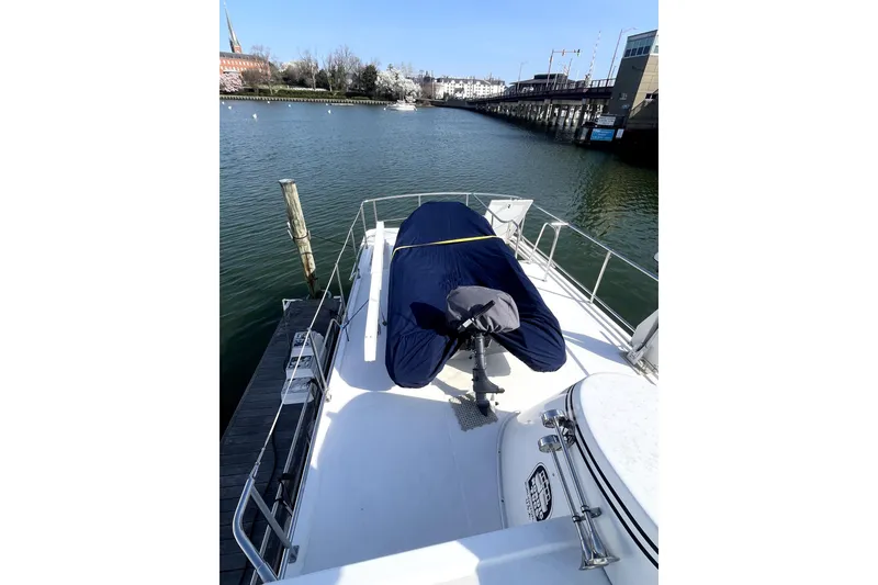 Slide: The Image of 2008 Nordic Tug 42 docked, covered deck, calm waters, urban backdrop. - 61