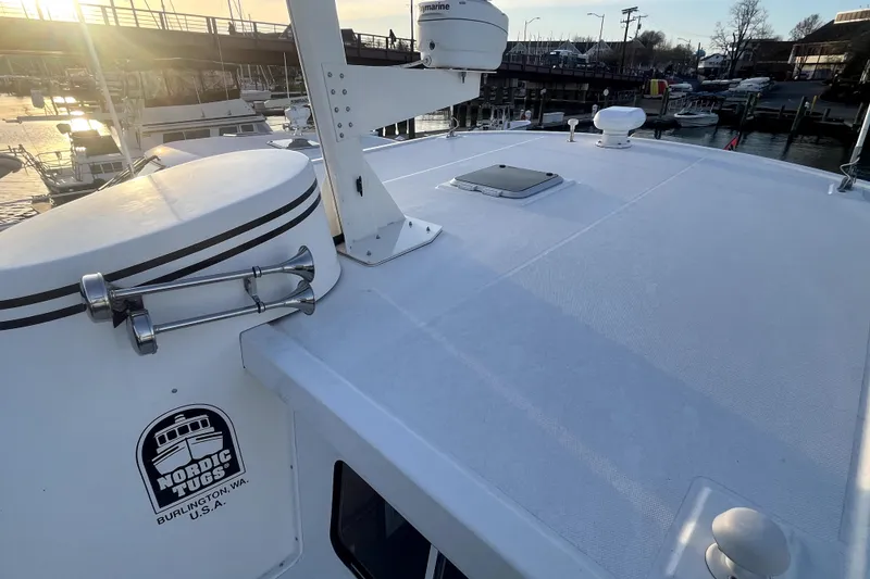Slide: The Image of 2008 Nordic Tug 42 boat deck at marina during sunset, showcasing radar and hatch. - 65