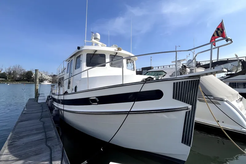 Slide: The Image of 2008 Nordic Tug 42 docked at marina under clear blue sky. - 7