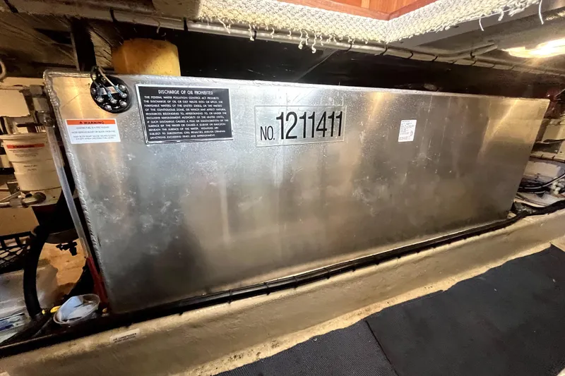 Slide: The Image of Fuel tank in 2008 Nordic Tug 42 engine room with warning labels and identification number. - 73
