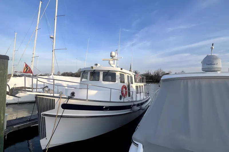Slide: The Image of 2008 Nordic Tug 42 docked at marina under clear blue sky. - 8