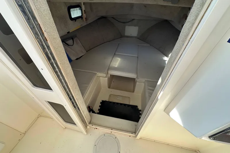 Slide: The Image of 2001 Parker 2510 Deep Vee Walkaround cabin interior with cushioned seating and storage. - 18