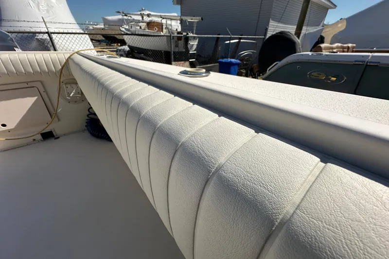 Slide: The Image of 2001 Parker 2510 Deep Vee Walkaround boat interior with cushioned seating and deck details. - 20