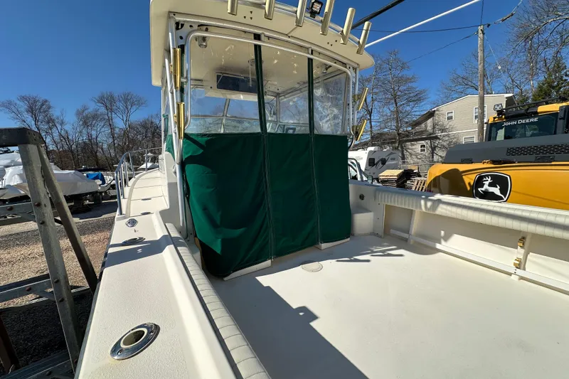 Slide: The Image of 2001 Parker 2510 Deep Vee Walkaround boat with green cover, docked outdoors. - 30