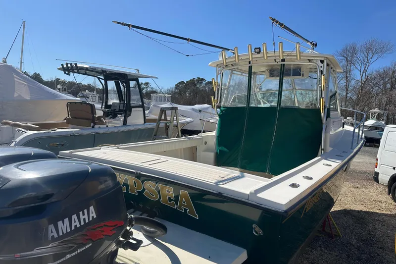 Slide: The Image of 2001 Parker 2510 Deep Vee Walkaround boat with Yamaha engine, docked outdoors. - 31