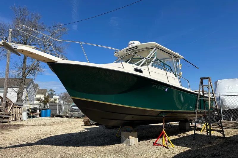 Slide: The Image of 2001 Parker 2510 Deep Vee Walkaround boat on stands, outdoor storage setting. - 33