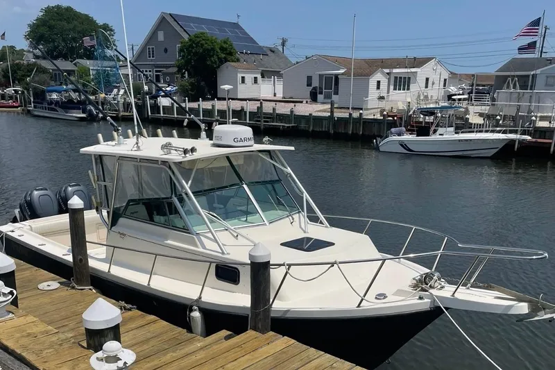 Slide: The Image of 2001 Parker 2510 Deep Vee Walkaround boat docked in a marina. - 4