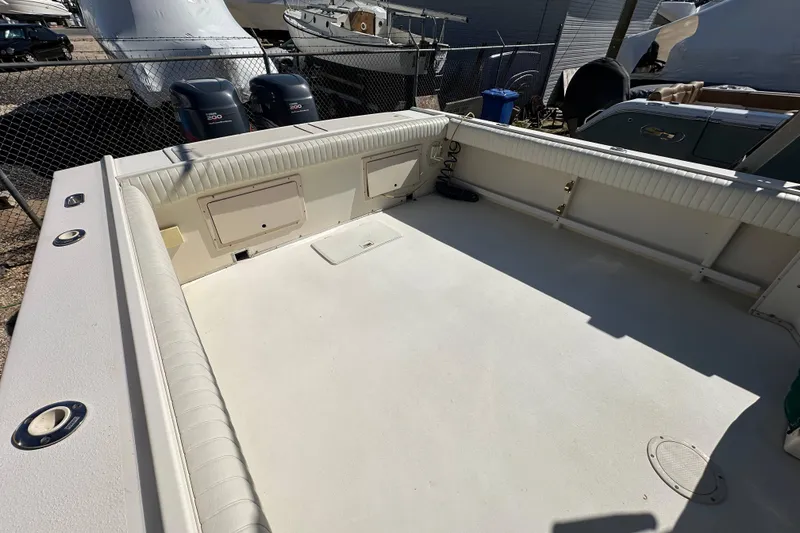 Slide: The Image of 2001 Parker 2510 Deep Vee Walkaround boat deck, spacious and well-maintained, in a marina setting. - 9