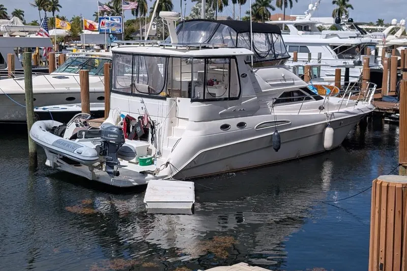 Slide: The Image of 2000 Sea Ray 420 Aft Cabin yacht docked at marina with inflatable boat. - 2