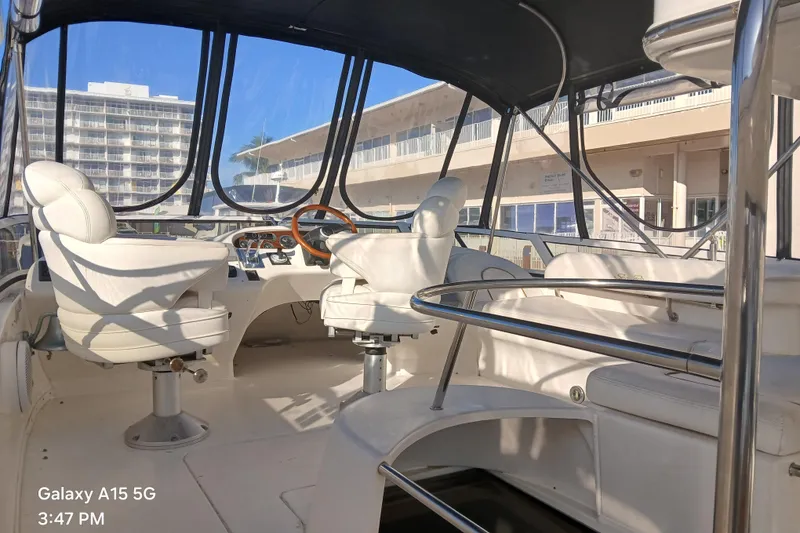 Slide: The Image of Interior view of 2000 Sea Ray 420 Aft Cabin yacht with white seating and steering wheel. - 6